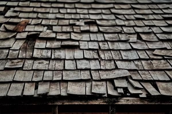 Close-up of damaged shingles needing roof repair in California