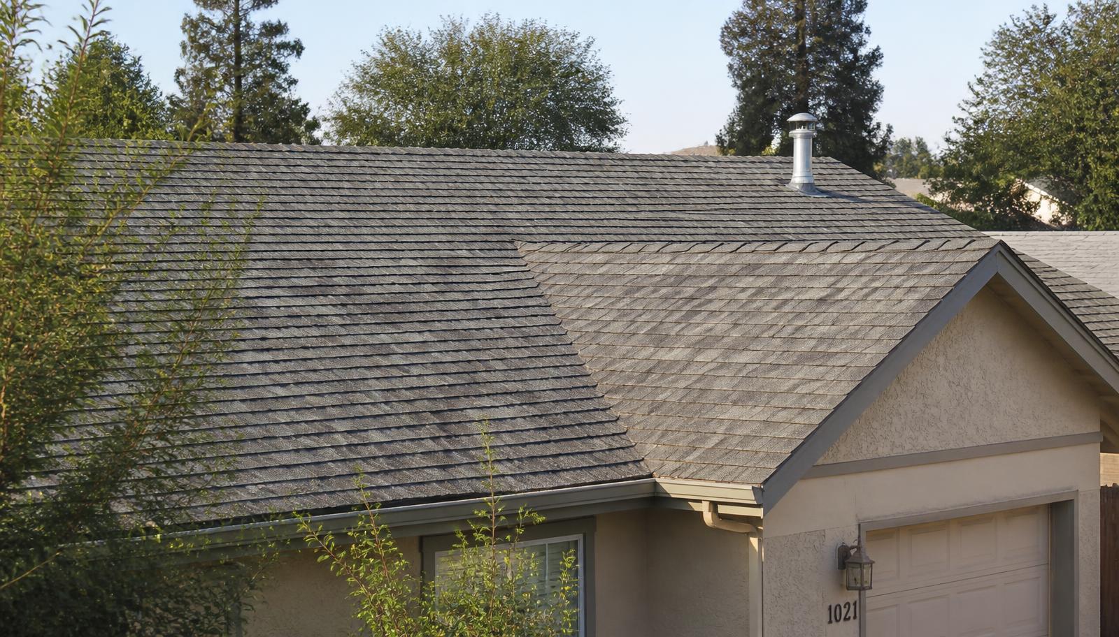 Aging asphalt shingle roof on a Selma home with faded, granule-worn shingles